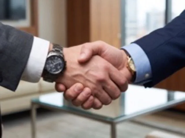 Zwei Geschäftspartner besiegeln eine Zusammenarbeit per Handschlag